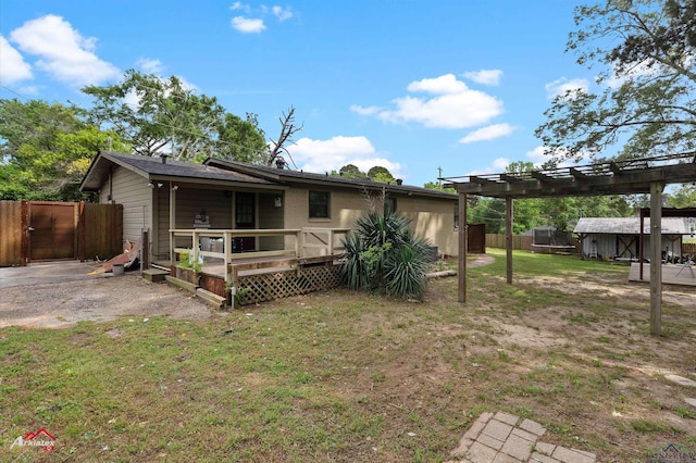 back of property with a lawn, a gate, a wooden deck, and fence