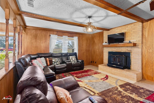 carpeted living room featuring visible vents, wood walls, a textured ceiling, and beamed ceiling