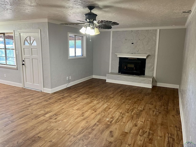 unfurnished living room with a fireplace, a textured ceiling, and crown molding