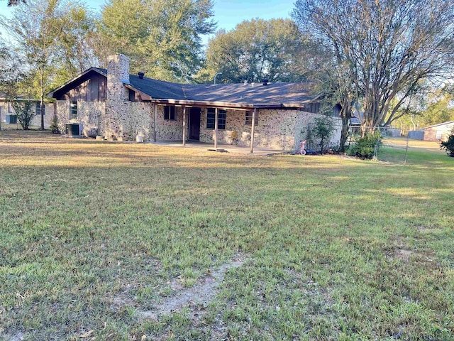 ranch-style house with central air condition unit and a front lawn