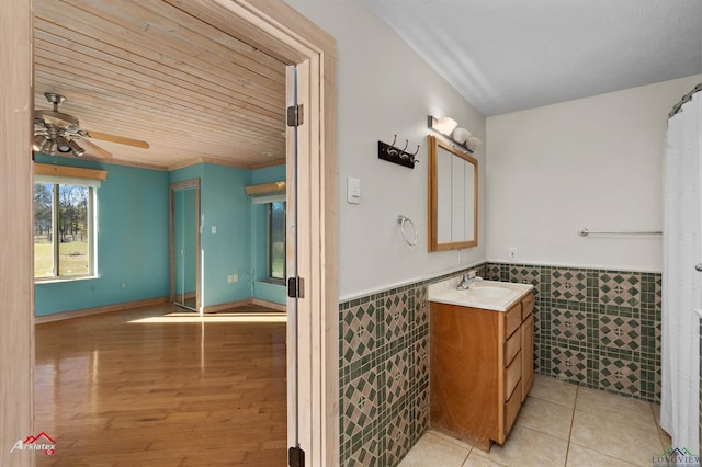 bathroom with vanity, wooden ceiling, tile patterned flooring, ceiling fan, and tile walls