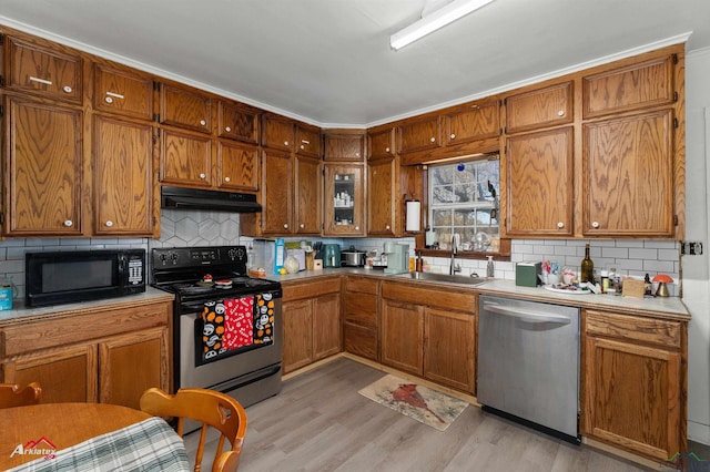 kitchen with dishwasher, sink, range with electric cooktop, decorative backsplash, and light hardwood / wood-style floors