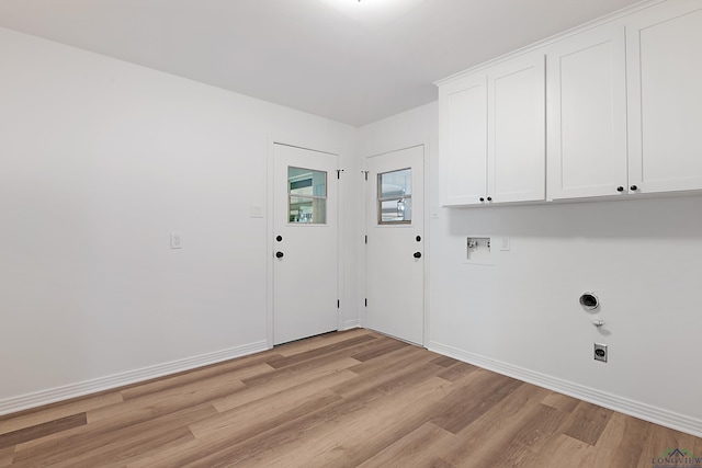 washroom featuring hookup for an electric dryer, washer hookup, light hardwood / wood-style flooring, and cabinets