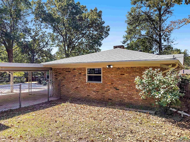 view of side of home with a carport and a patio