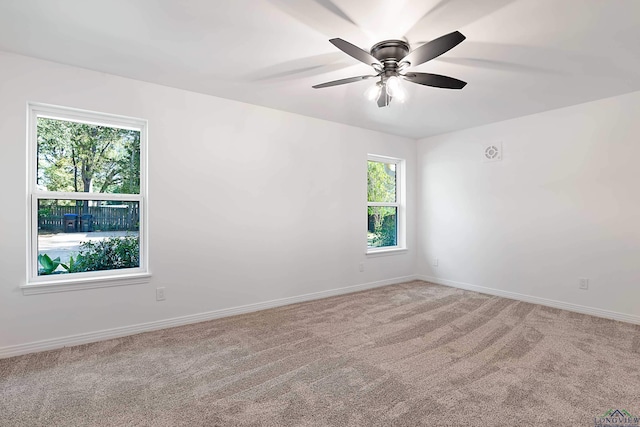 carpeted spare room featuring ceiling fan