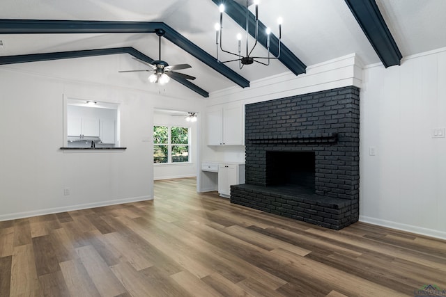 unfurnished living room with a fireplace, lofted ceiling with beams, ceiling fan with notable chandelier, and wood-type flooring