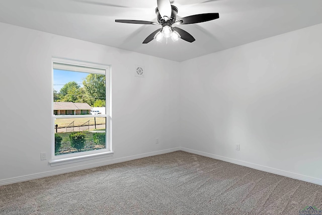 carpeted spare room featuring ceiling fan