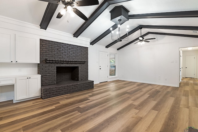 unfurnished living room featuring a fireplace, hardwood / wood-style floors, vaulted ceiling with beams, and ceiling fan with notable chandelier