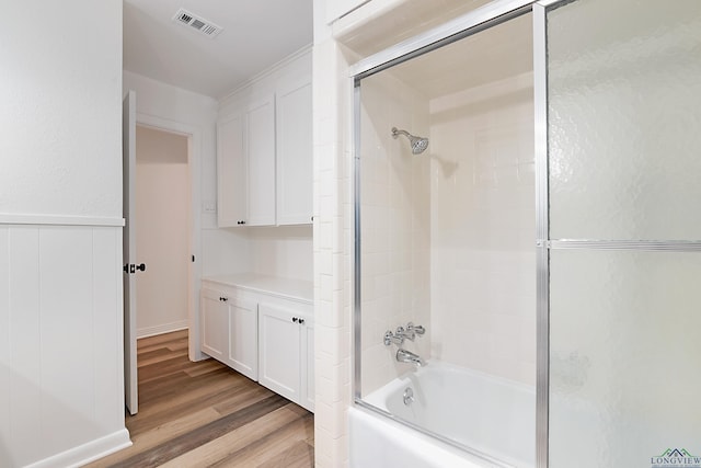 bathroom with shower / bath combination with glass door and hardwood / wood-style floors