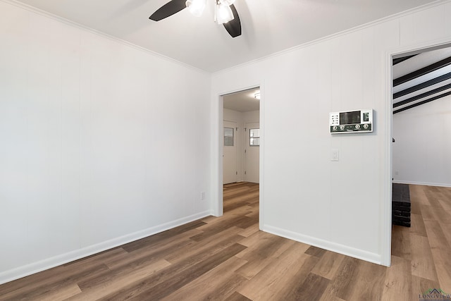 spare room featuring beam ceiling, ceiling fan, ornamental molding, and hardwood / wood-style flooring