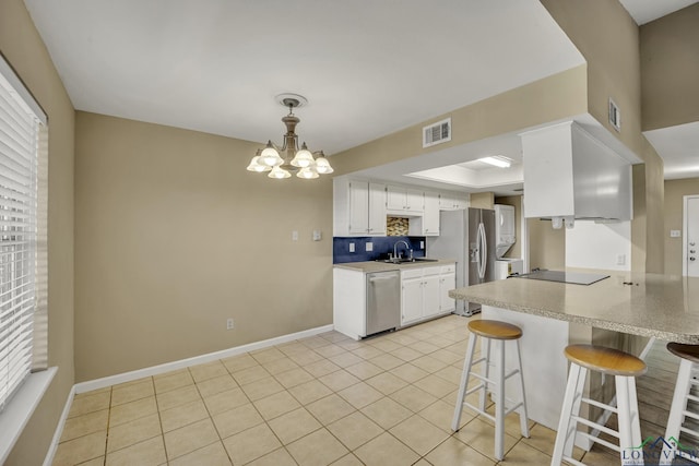 kitchen featuring stainless steel appliances, sink, light tile patterned floors, an inviting chandelier, and white cabinets