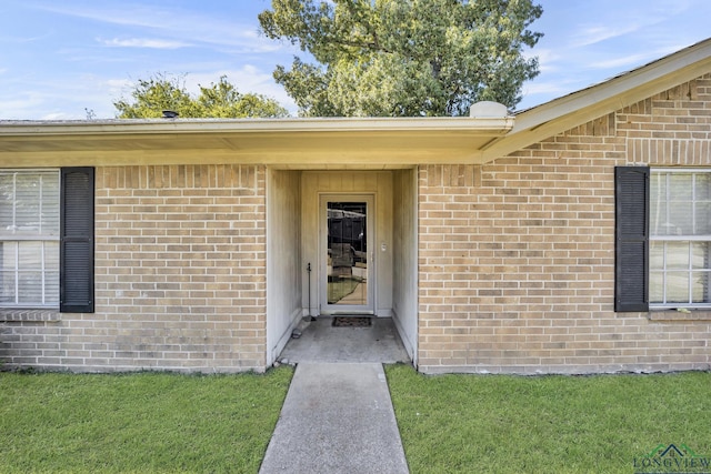 view of exterior entry with a yard