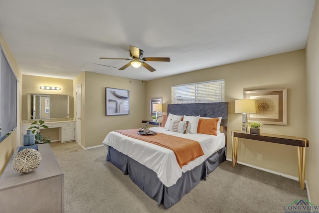 bedroom with light carpet, ensuite bathroom, and ceiling fan