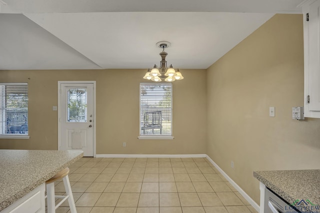 unfurnished dining area with light tile patterned floors and an inviting chandelier