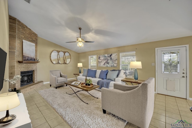 living room featuring ceiling fan, light tile patterned flooring, lofted ceiling, and a brick fireplace