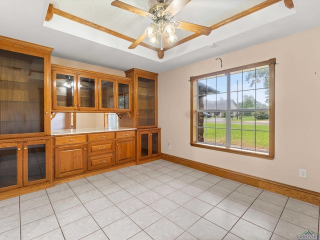 kitchen featuring a raised ceiling, ceiling fan, and light tile patterned floors