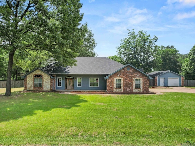 ranch-style house featuring an outbuilding, a garage, and a front lawn