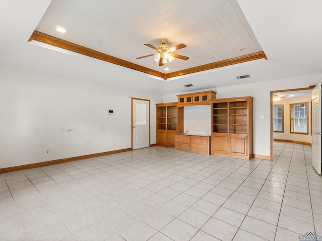 unfurnished living room featuring a tray ceiling, ceiling fan, and light tile patterned floors