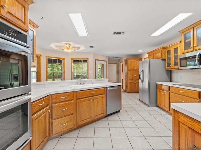 kitchen featuring sink, ceiling fan, light tile patterned floors, tasteful backsplash, and stainless steel appliances