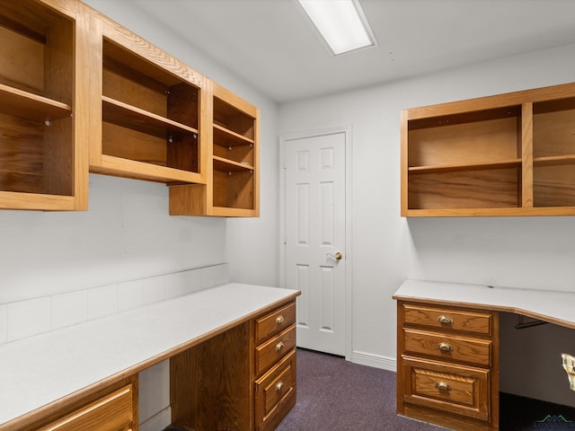 carpeted office space featuring built in desk