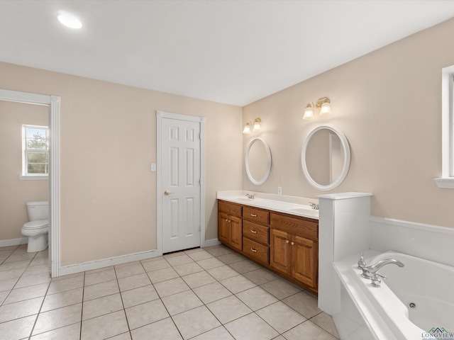 bathroom with tile patterned floors, vanity, toilet, and a tub