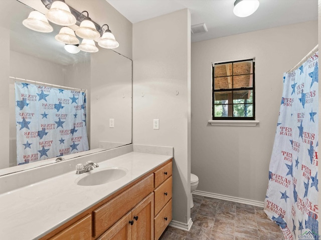 bathroom featuring walk in shower, vanity, and toilet