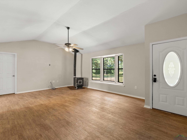 entryway featuring a wood stove, ceiling fan, and lofted ceiling