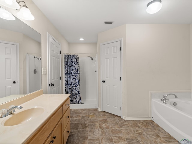 bathroom featuring vanity and independent shower and bath