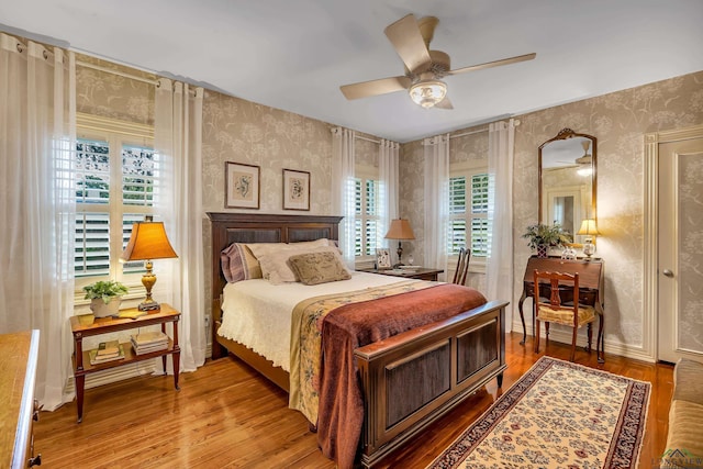 603 E Melton, Longview, TX 75602 - bedroom featuring wallpapered walls, multiple windows, wood finished floors, and ceiling fan