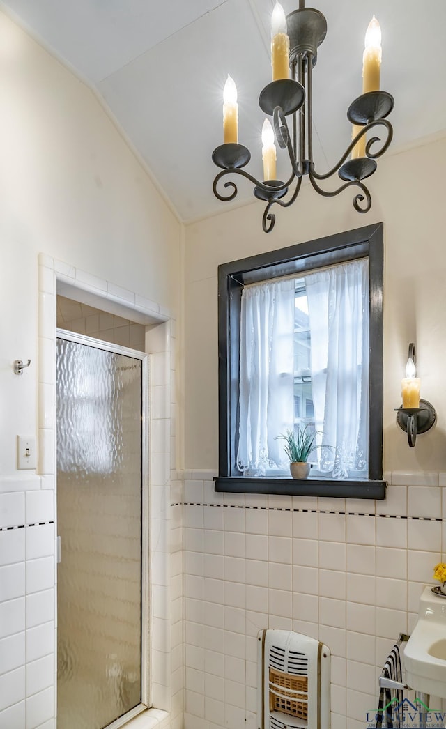 603 E Melton, Longview, TX 75602 - bathroom featuring tile walls, heating unit, a shower stall, a chandelier, and a wainscoted wall