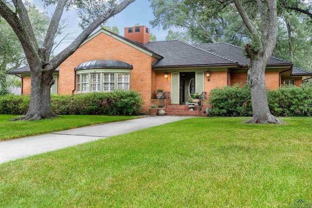 603 E Melton, Longview, TX 75602 - view of front facade featuring brick siding, a front yard, and a chimney