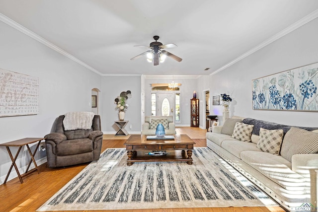 living room with ceiling fan with notable chandelier, light hardwood / wood-style floors, and crown molding