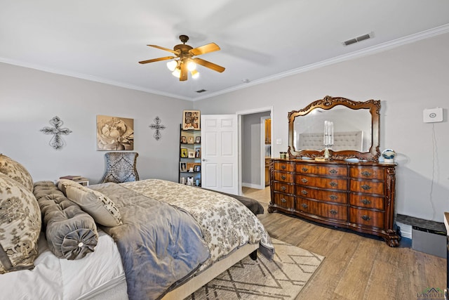 bedroom featuring ceiling fan, crown molding, and hardwood / wood-style floors