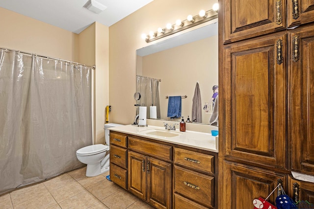 bathroom with toilet, vanity, and tile patterned floors