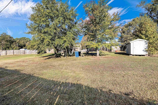 view of yard featuring a playground and a shed