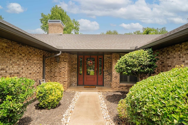 1902 W Warwick Cir, Longview, TX 75601 - entrance to property featuring brick siding, roof with shingles, a chimney, and a porch
