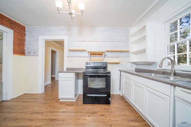 kitchen featuring white cabinetry, electric range, sink, wood walls, and white dishwasher