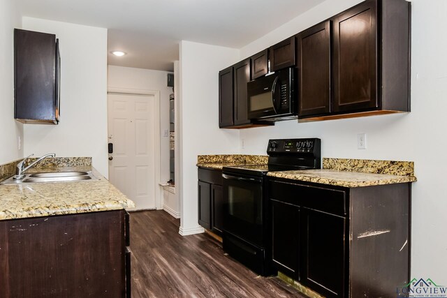 1205 Booker St, Longview, TX 75602 - kitchen featuring black appliances, dark wood-type flooring, dark brown cabinetry, and recessed lighting