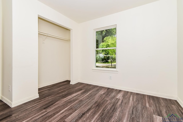 1205 Booker St, Longview, TX 75602 - unfurnished bedroom featuring dark wood-type flooring and a closet