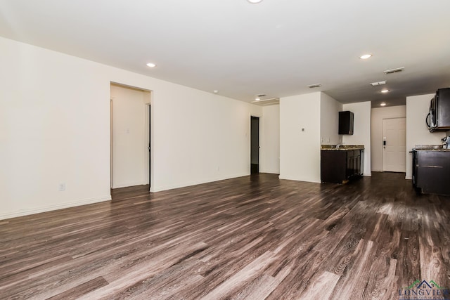 1205 Booker St, Longview, TX 75602 - unfurnished living room with dark wood-style floors and recessed lighting