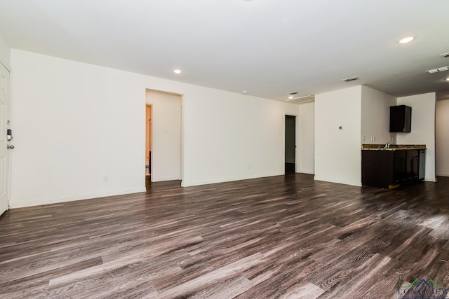 1205 Booker St, Longview, TX 75602 - unfurnished living room featuring dark wood finished floors and recessed lighting