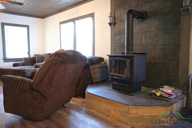 521 N Montgomery St, Gilmer, TX 75644 - living area with a wood stove, wood finished floors, wooden ceiling, and a ceiling fan