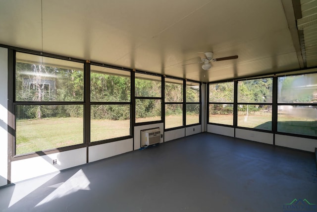 unfurnished sunroom featuring ceiling fan and a wall mounted AC