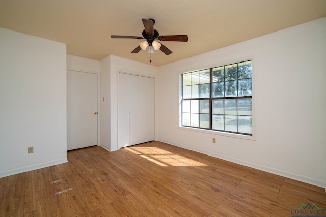 unfurnished bedroom featuring ceiling fan, light hardwood / wood-style floors, and a closet