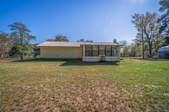 back of property featuring a yard and a sunroom