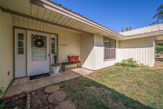 property entrance featuring a lawn