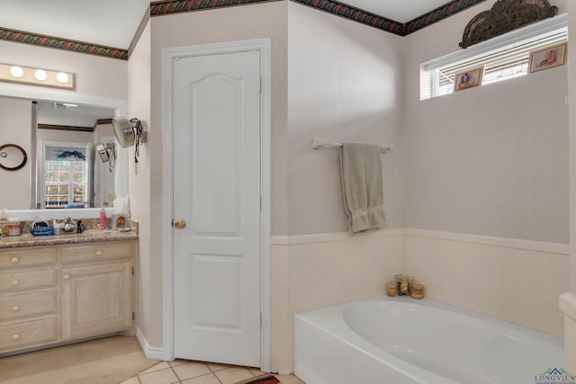 bathroom featuring tile patterned floors, a tub to relax in, and vanity