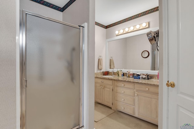 bathroom with vanity and a shower with door