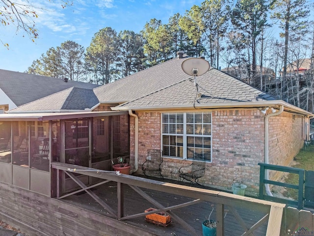 rear view of house featuring a sunroom