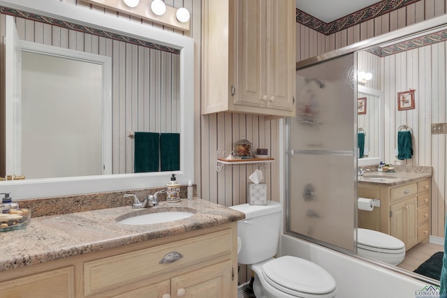 full bathroom with toilet, vanity, and shower / bath combination with glass door